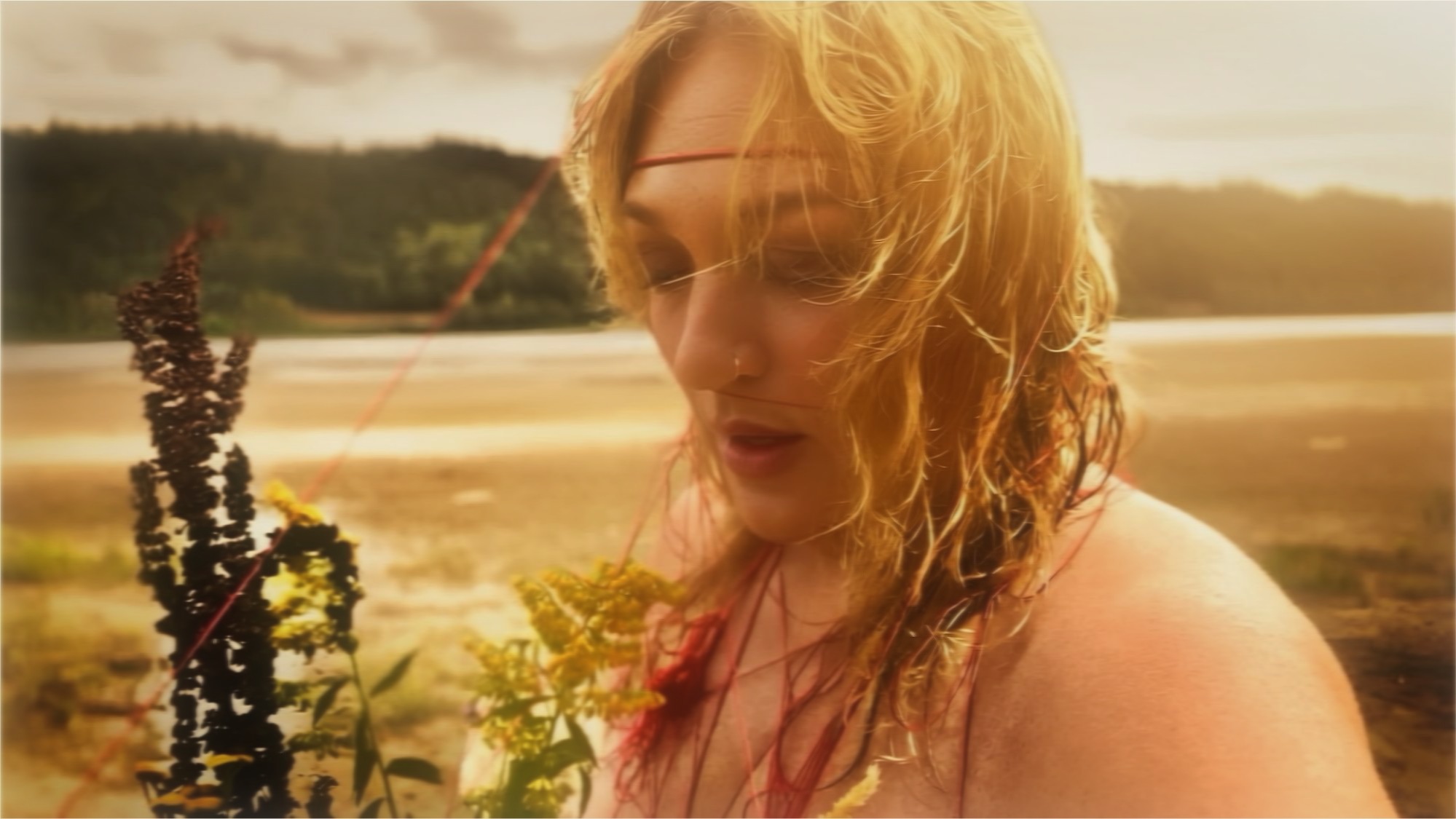 Red Thread, further work. Eyes lowered by the river, red thread across the brow, goldenrod and dock in the foreground.