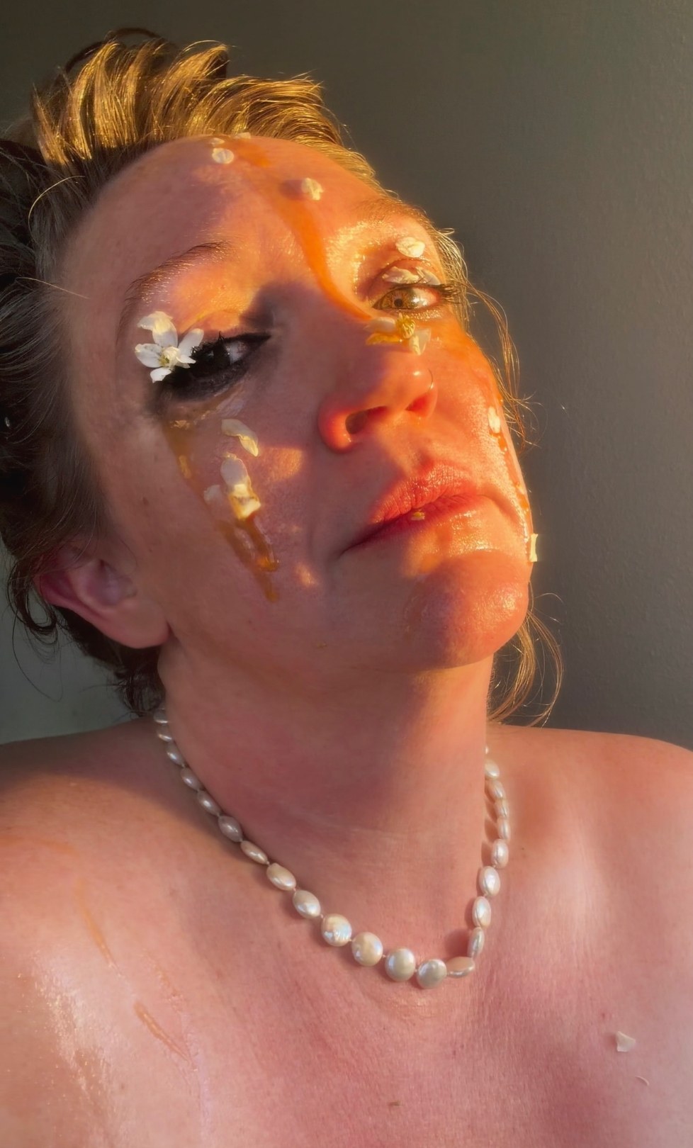 Taste and See, 3 of 5. Head tipped back in hard sun, a flower over one eye, mascara smudged beneath the other, honey running down the cheek like tears.